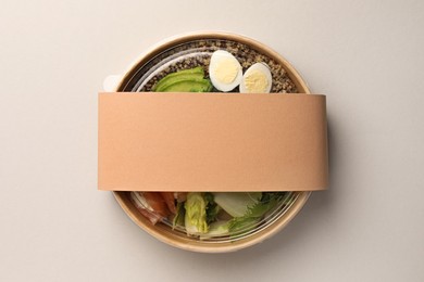 Tasty food in container on light background, top view. Space for text