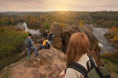 Photo of Group of hikers with backpacks climbing down mountain