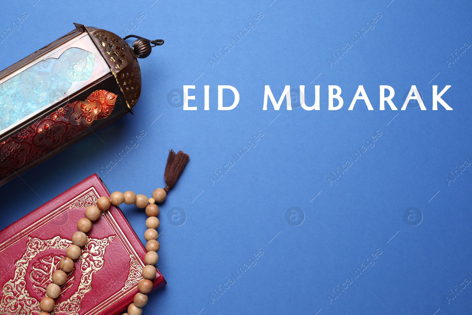 Image of Eid Mubarak greeting card. Arabic lantern, Quran and misbaha on blue background, flat lay