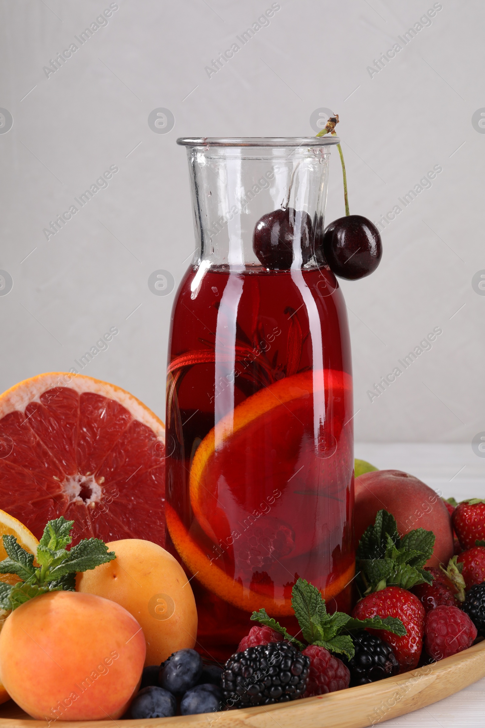 Photo of Delicious refreshing sangria, fruits and berries on table