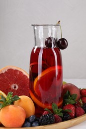 Delicious refreshing sangria, fruits and berries on table