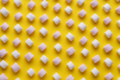 Photo of Delicious puffy marshmallows on yellow background, flat lay