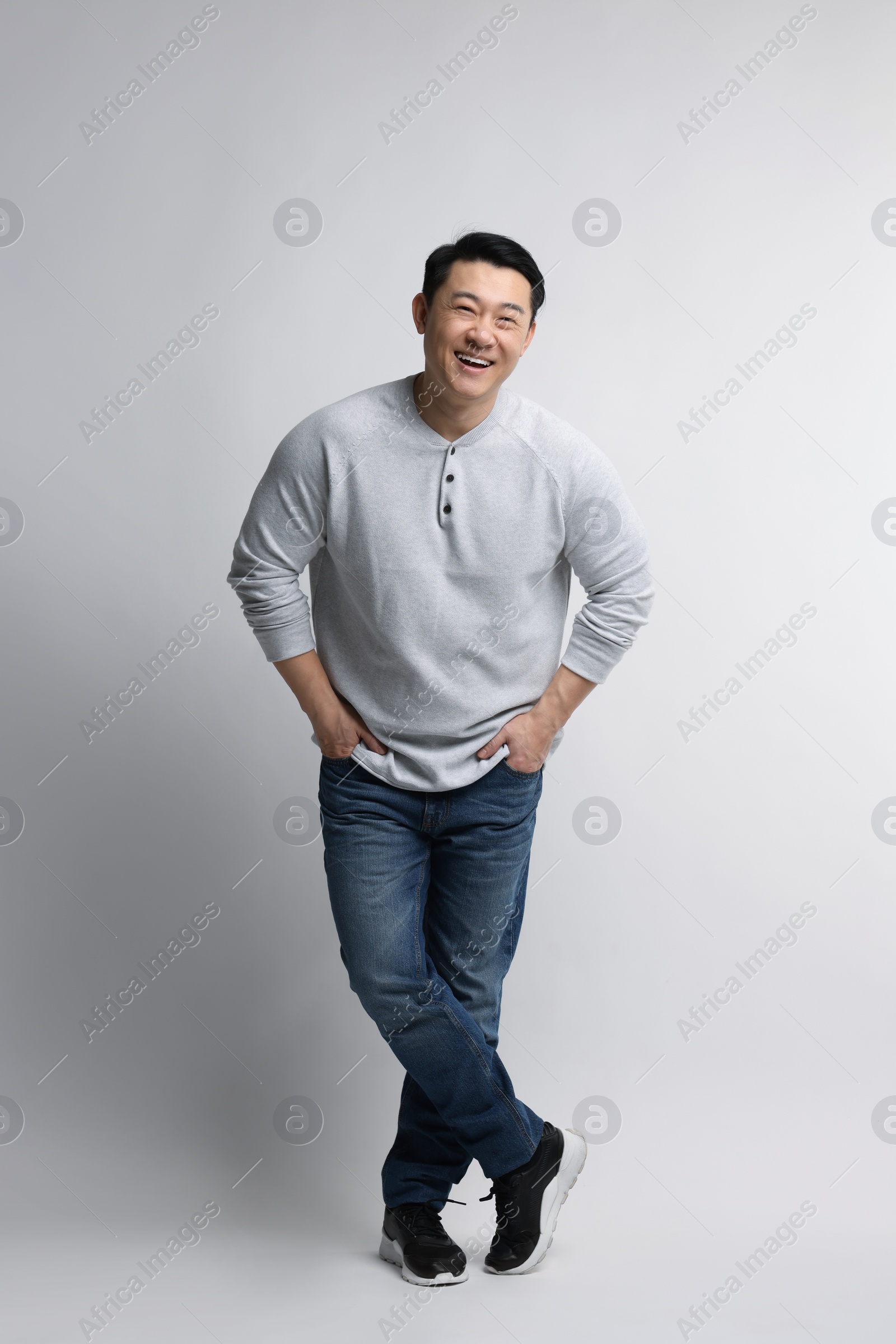 Photo of Full length portrait of happy man on light background