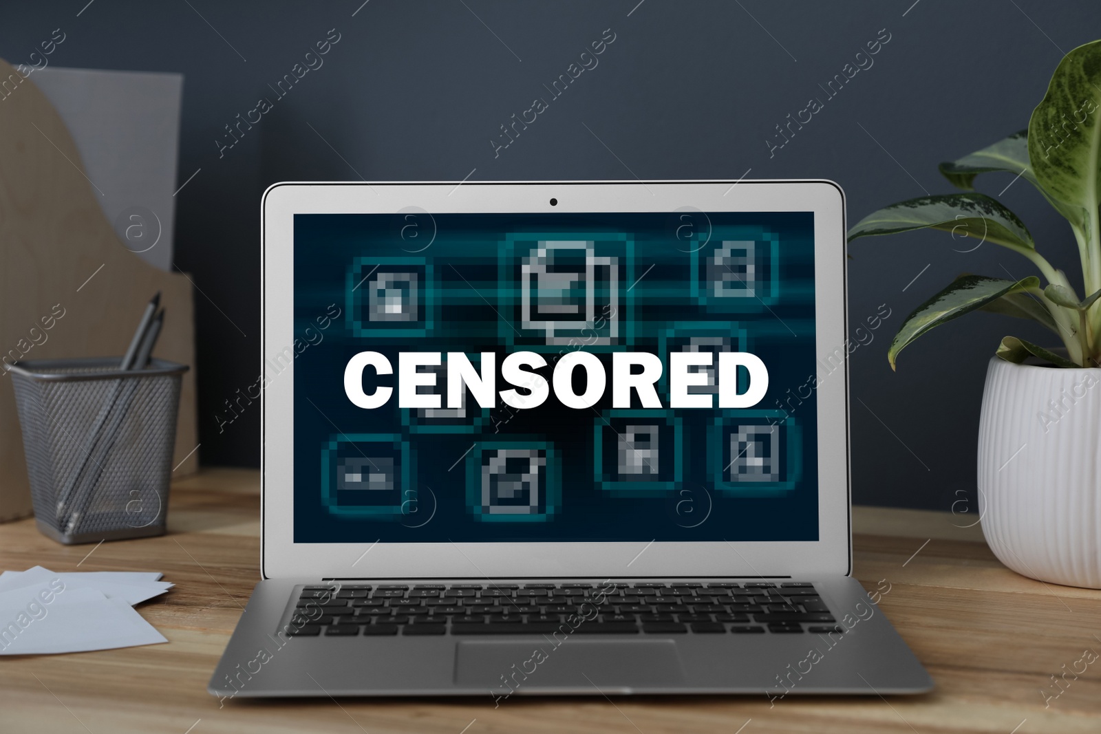 Image of Laptop with censorship sign on wooden table