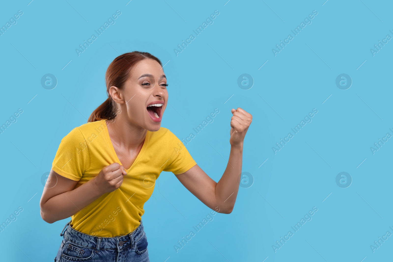 Photo of Emotional fan celebrating on light blue background, space for text