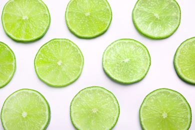 Photo of Juicy fresh lime slices on white background, top view