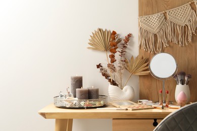 Photo of Dressing table with mirror, makeup products and decor in room. Space for text