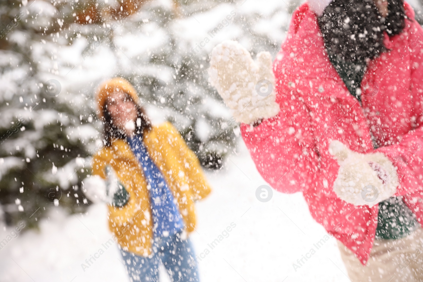 Photo of Happy friends playing snowballs outdoors. Winter vacation