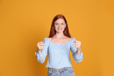 Photo of Happy young woman pretending to drive car on yellow background
