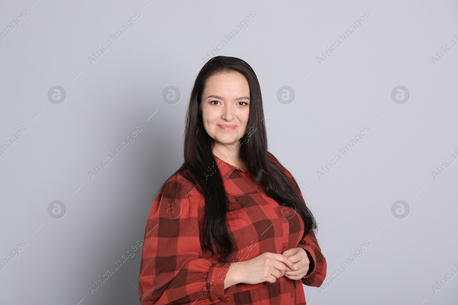 Photo of Beautiful overweight woman with charming smile on light grey background