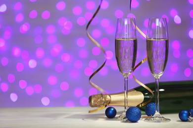 Photo of New year composition with champagne and space for text against blurred Christmas lights