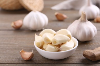 Aromatic garlic cloves and bulbs on wooden table, closeup. Space for text