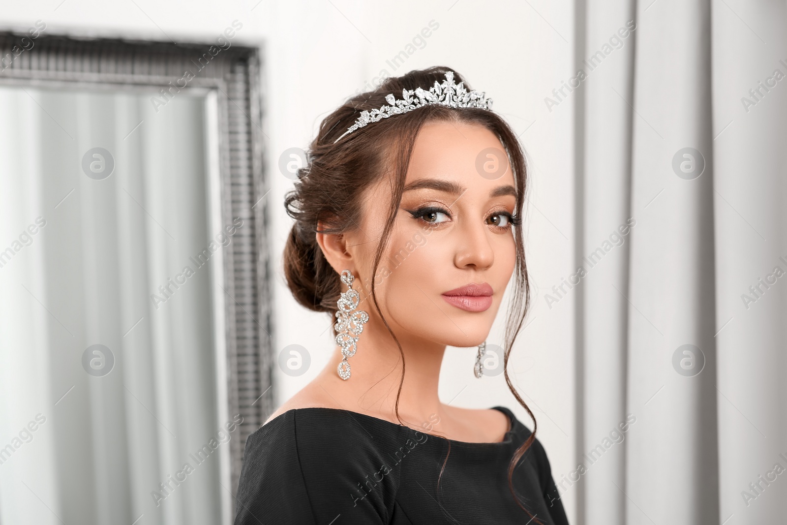 Photo of Beautiful young woman wearing luxurious tiara indoors