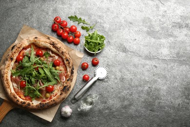 Photo of Tasty pizza with meat and arugula on grey table, flat lay. Space for text