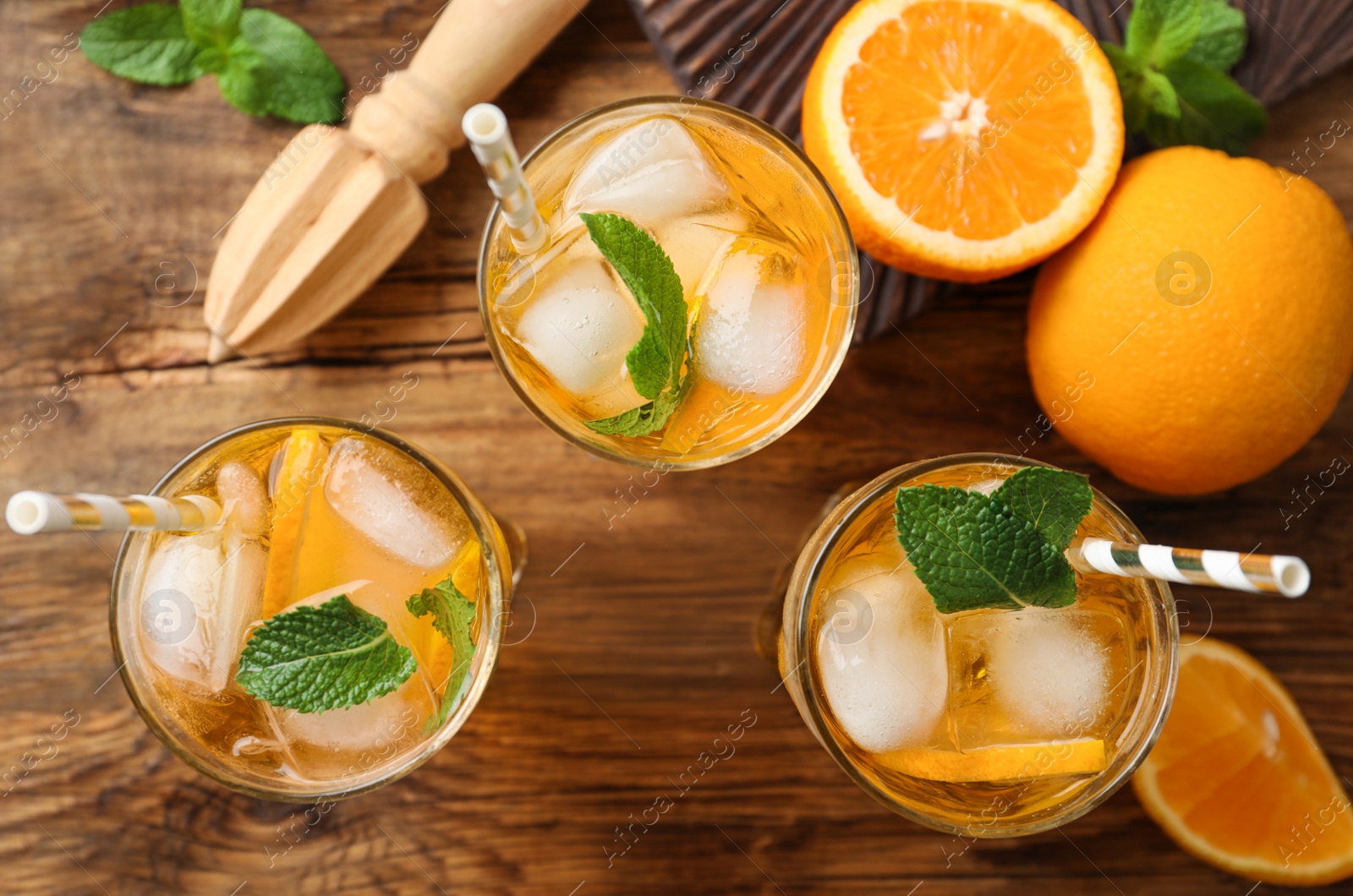 Photo of Delicious refreshing drink with orange slices on wooden table, flat lay