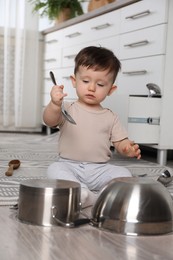 Photo of Cute little boy with cookware at home