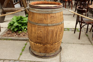 Photo of Traditional wooden barrel on street outdoors. Wine making