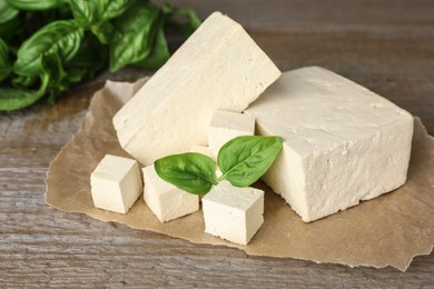 Photo of Delicious tofu with basil on wooden table