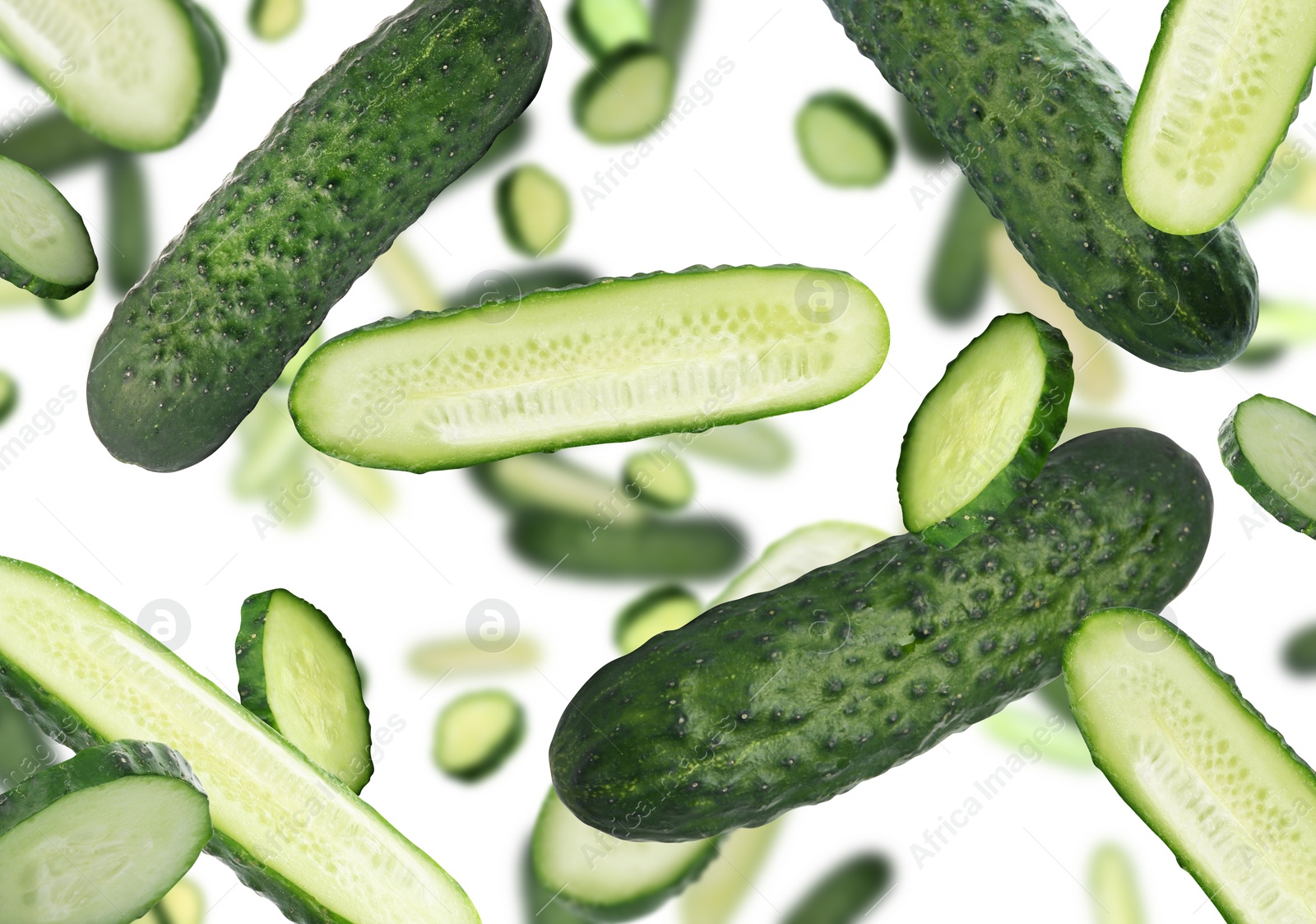 Image of Fresh green cucumbers falling on white background