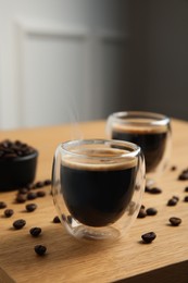 Photo of Tasty coffee and beans on wooden table indoors