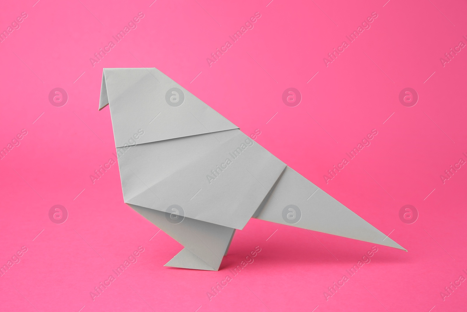 Photo of Paper bird on pink background. Origami art