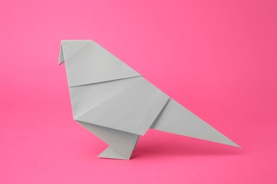 Paper bird on pink background. Origami art