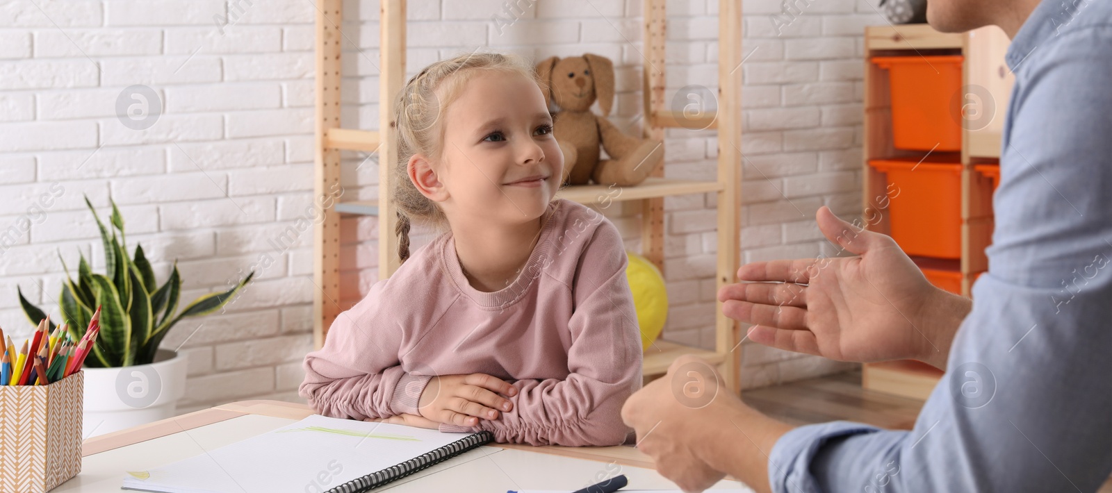 Image of Child psychotherapist working with little girl in office