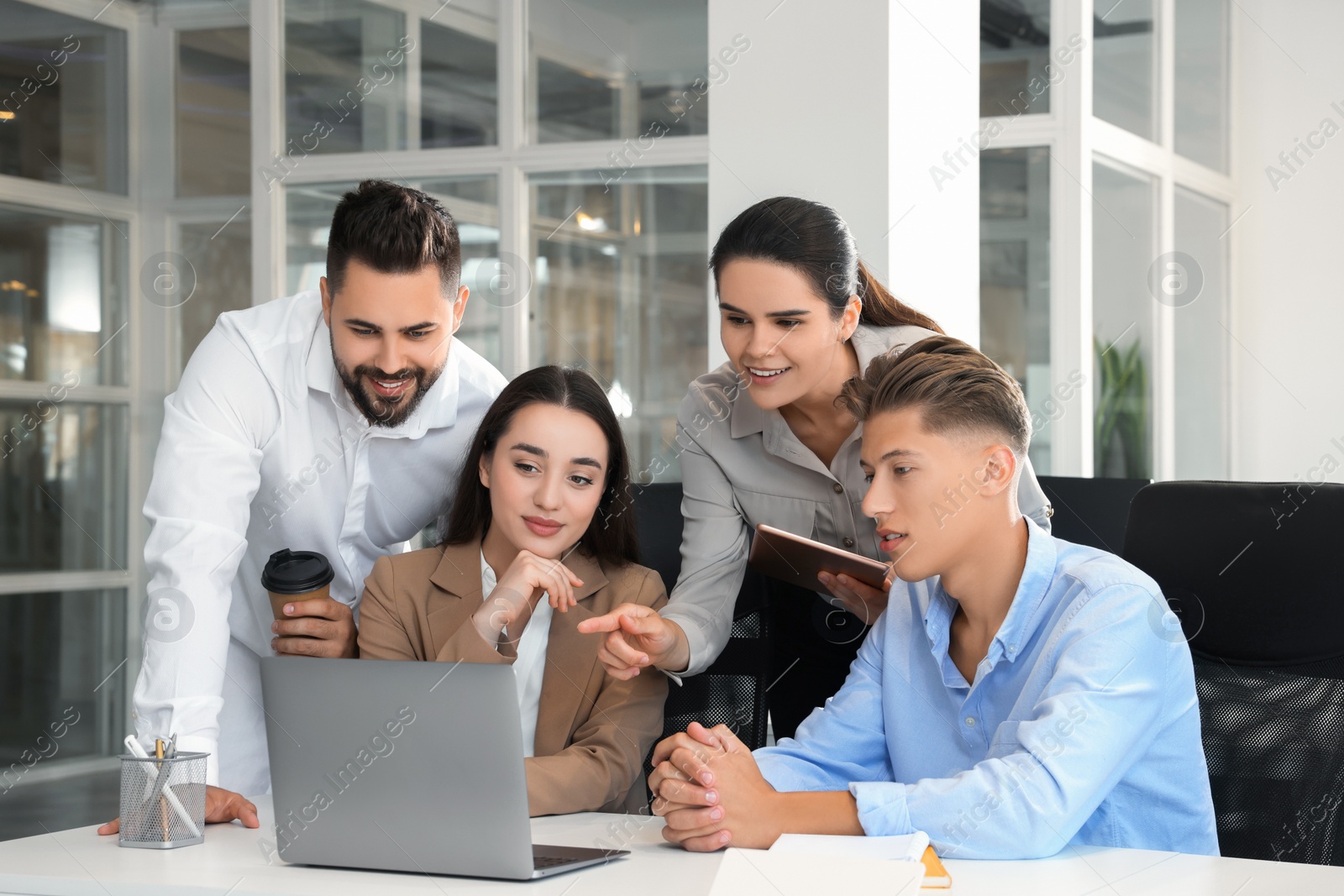 Photo of Colleagues working together in open plan office