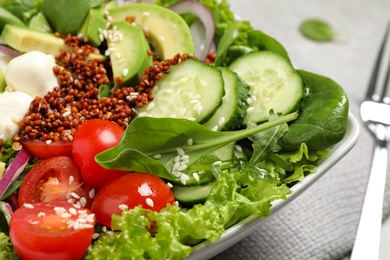Photo of Delicious avocado salad with quinoa on light grey table, closeup