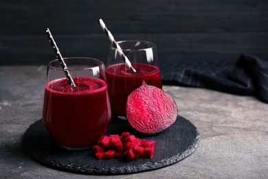 Slate plate with glasses of beet smoothies on table