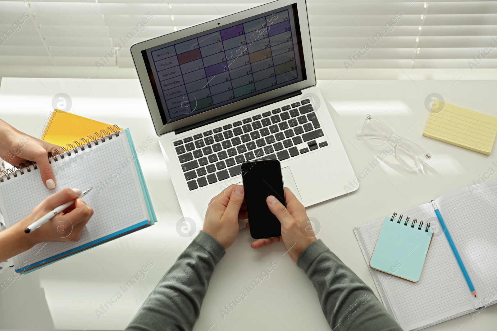 Photo of Colleagues using calendar app on laptop in office, above view