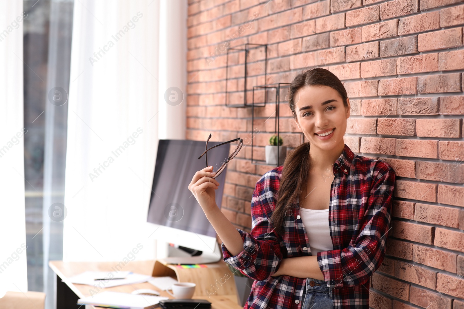 Photo of Professional journalist near brick wall in office