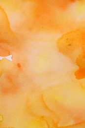 Abstract yellow and orange watercolor painting as background, top view