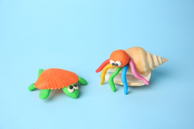 Photo of Turtle and crab made from plasticine on light blue background. Children's handmade ideas
