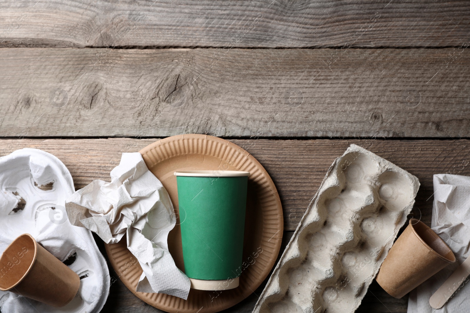 Photo of Waste paper on wooden table, flat lay. Space for text