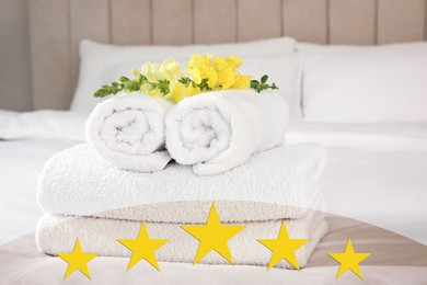 Image of Fresh white towels with flower on bed in five star hotel room
