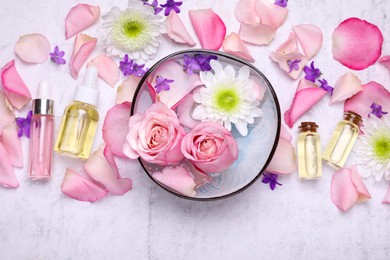 Photo of Flat lay composition with bowl of water and beautiful flowers on light table. Spa treatment