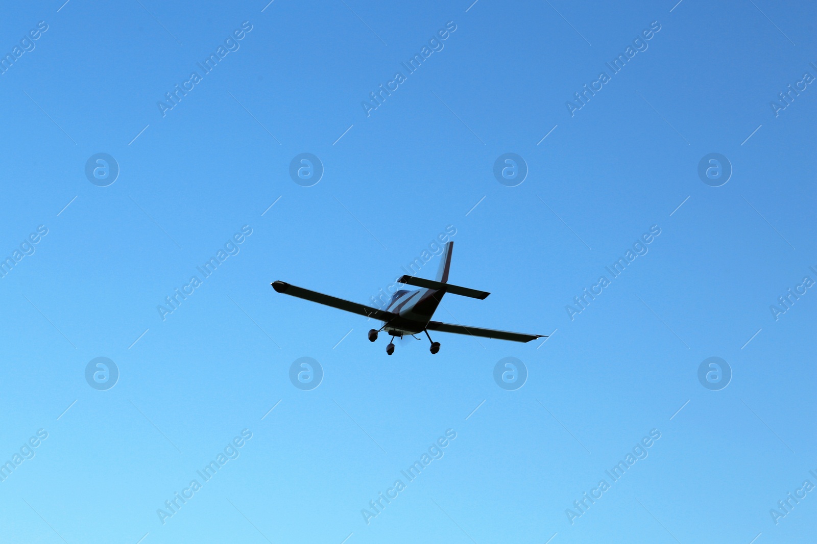 Photo of Modern ultralight airplane flying in blue sky