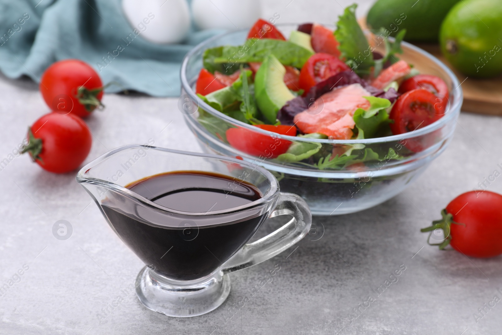 Photo of Soy sauce and vegetable salad on grey table, selective focus