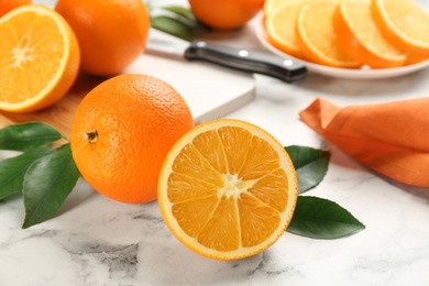 Photo of Delicious ripe oranges on white marble table