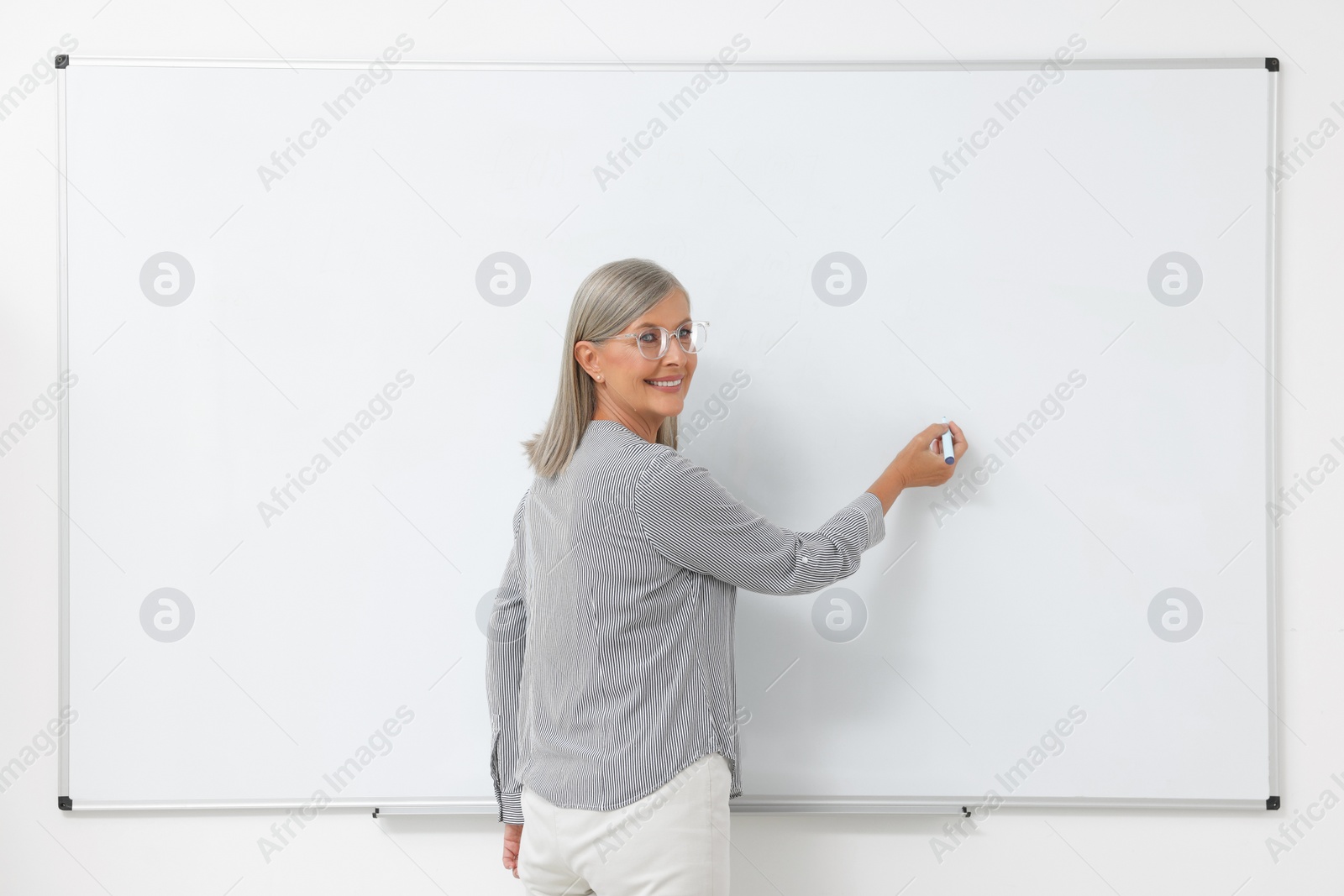 Photo of Portrait of professor explaining something at whiteboard indoors