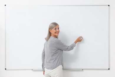Portrait of professor explaining something at whiteboard indoors