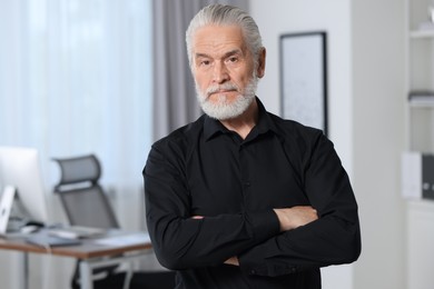 Portrait of handsome senior man in black shirt at home