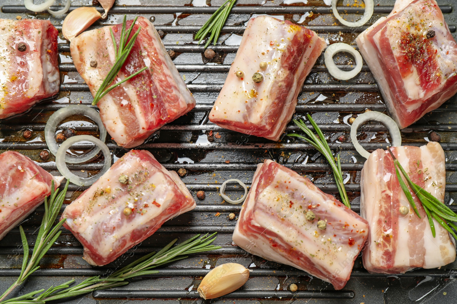 Photo of Grill pan with raw ribs and seasonings, flat lay