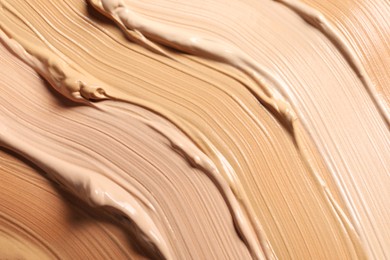 Photo of Samples of skin foundation as background, closeup