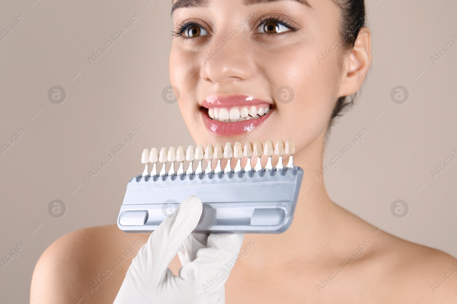 Photo of Dentist checking young woman's teeth color, closeup
