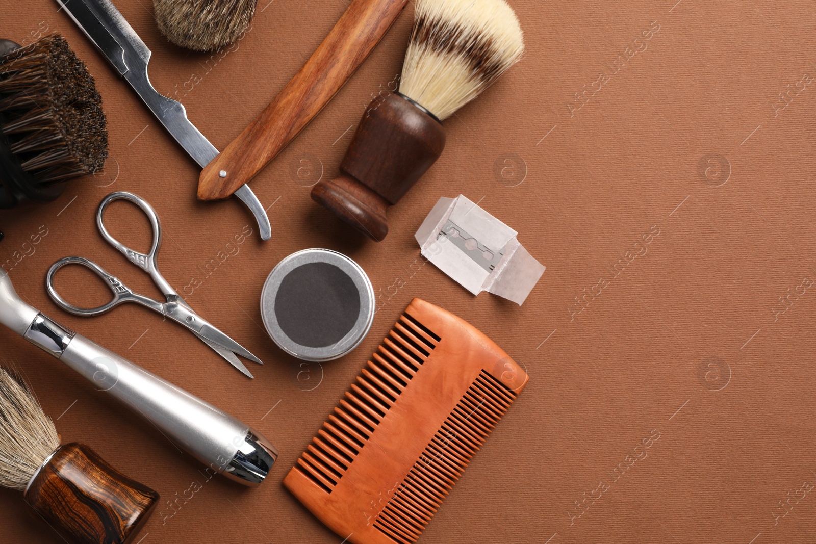 Photo of Moustache and beard styling tools on brown background, flat lay. Space for text