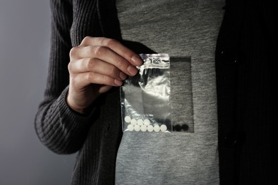 Photo of Female dealer holding drugs in plastic bag, closeup