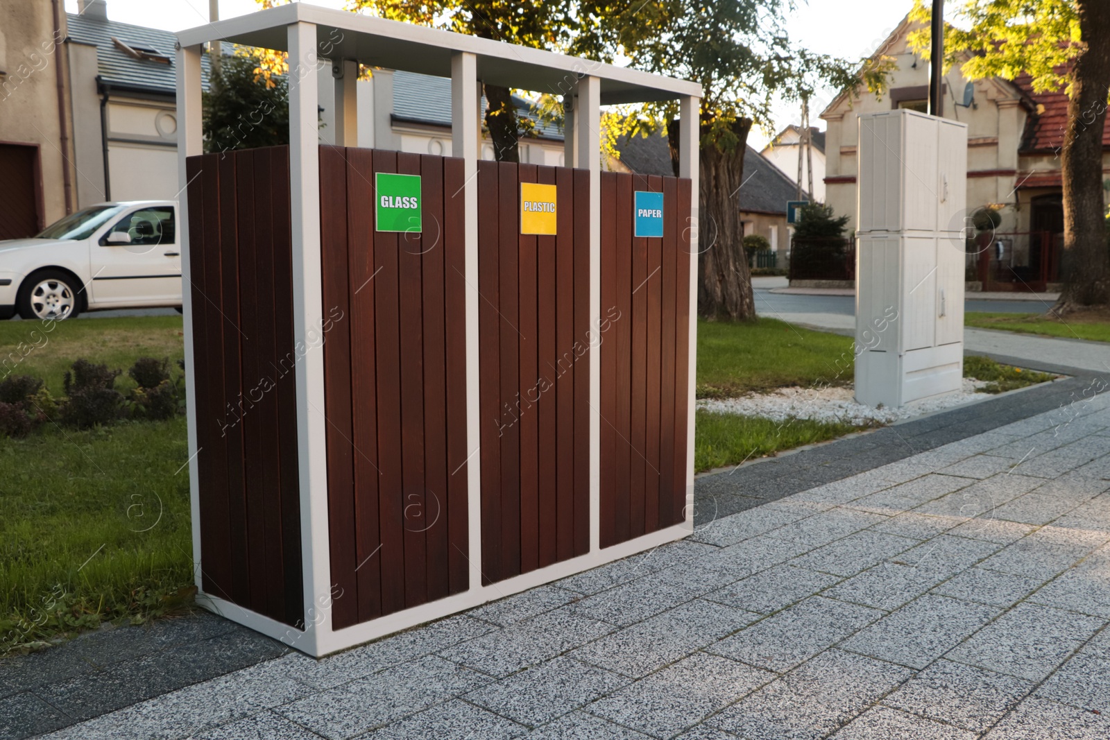 Photo of Different sorting bins for waste recycling on city street outdoors