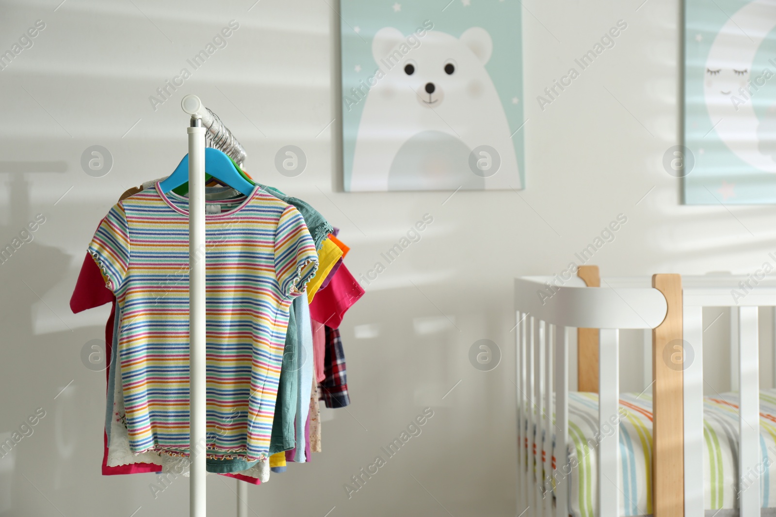 Photo of Different clothes hanging on rack in bedroom